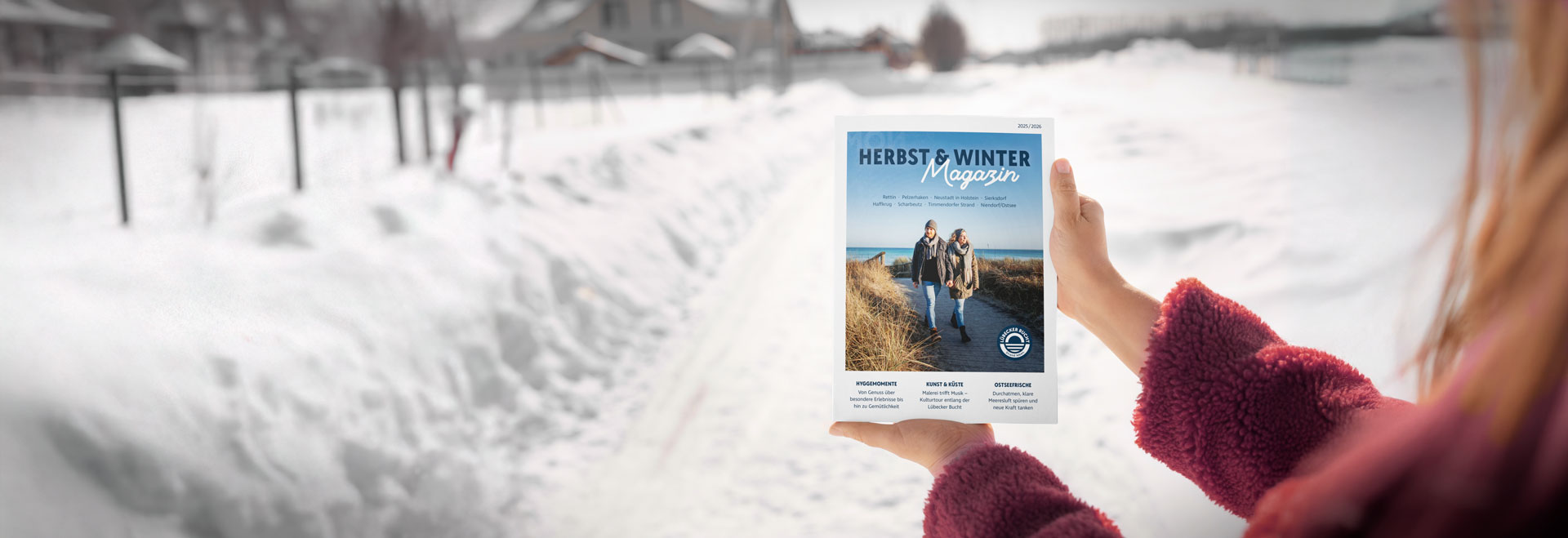 Der Titel des Herbst & Wintermagazins 2025/2026 der Lübecker Bucht wird vor winterlicher Kulisse gezeigt.