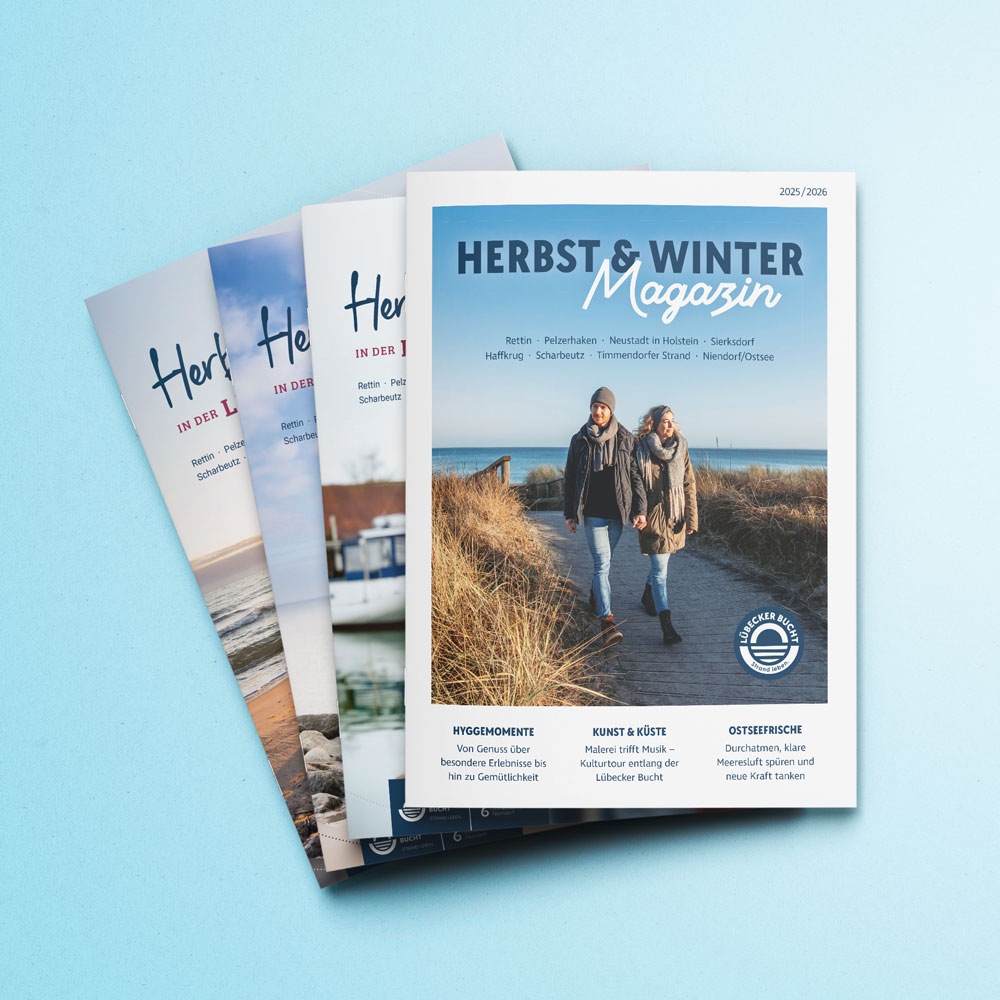Das aktuelle und die drei letzten Herbst- und Winter-Magazine der Lübecker Bucht liegen übereinander.